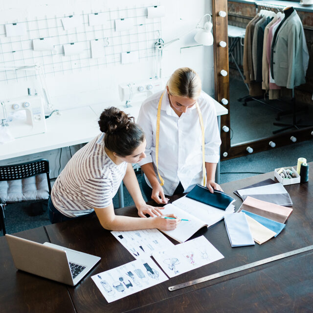 La styliste directeur artistique chez ALSO Fashion discute des croquis de mode avec la modéliste